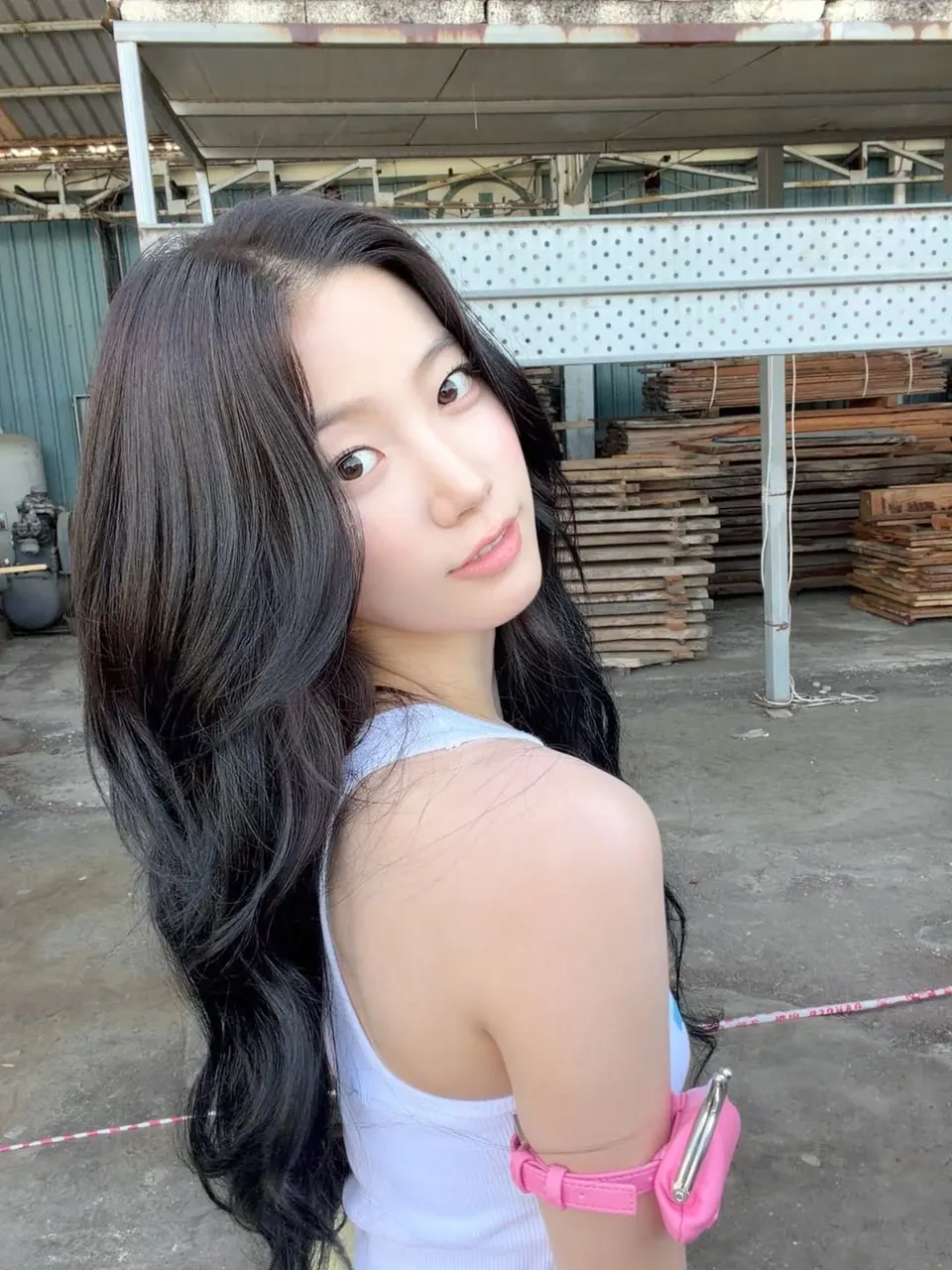 zaleysh menoleh ke kamera dengan rambut panjang dan tas kecil pink